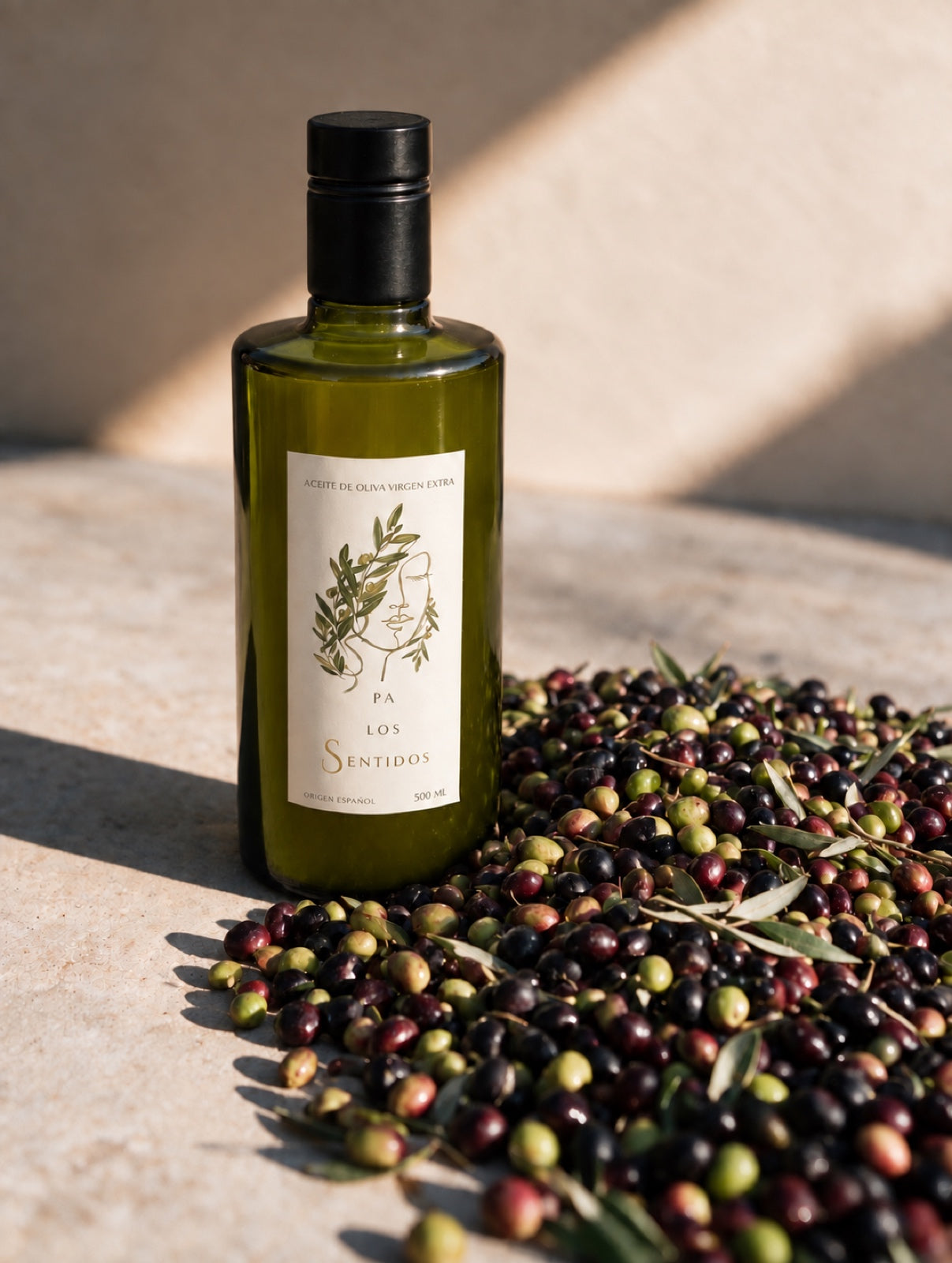 Botella de AOVE Pa los Sentidos junto a aceitunas recién cosechadas